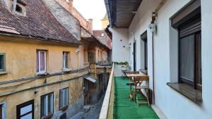 an alley between two buildings with a green floor at Town Square Apartment in Braşov