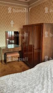 een slaapkamer met een bed, een dressoir en een spiegel bij DEBED in Alaverdi
