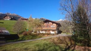une maison sur une colline avec des montagnes en arrière-plan dans l'établissement Chalet Pfyffer - Mountain view, à Grindelwald