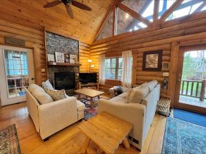 a living room with couches and a fireplace in a log cabin at Evergreen in Oakland