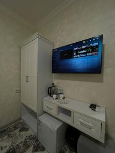 een kamer met een tv aan de muur en een bureau bij Гостевой дом Сардор in Samarkand