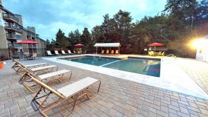 a swimming pool with lounge chairs and a swimming pool at Mountain Green Condos at Killington in Killington