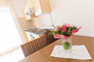 um vaso de flores sentado numa mesa numa cozinha em Haus Burger em Vilpiano