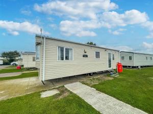a mobile home is parked in a yard at Superb 6 Berth Caravan At Martello Beach, Near Clacton-on-sea Ref 29008mc in Clacton-on-Sea