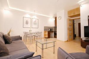 un soggiorno con divano e tavolo di Victus Apartamenty, Apartament Chill a Sopot