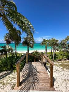 a wooden pathway to the beach with palm trees at Wally Love home in Savannah Sound