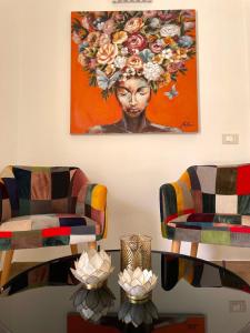 een woonkamer met 2 stoelen en een schilderij aan de muur bij B&B SoleLuna in Lampedusa