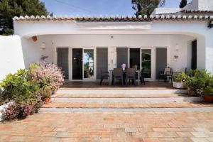 Cette maison blanche dispose d'une terrasse avec une table et des chaises. dans l'établissement Quinta da Balaia V3, à Albufeira