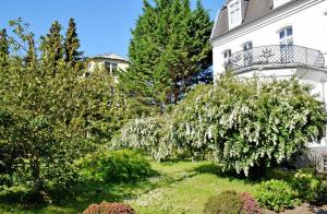 a white house with flowering trees in the yard at Villa im Ostseebad Baabe in Baabe