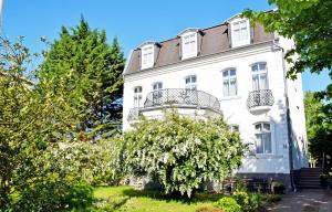 ein weißes Gebäude mit Balkon darüber in der Unterkunft Villa im Ostseebad Baabe in Baabe