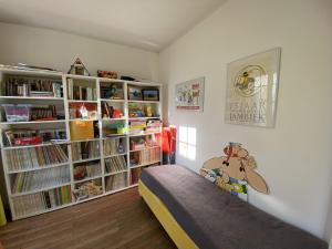 ein Schlafzimmer mit einem Bücherregal voller Bücher in der Unterkunft Maison de ville 2 etoile proche plage in Les Sables-dʼOlonne