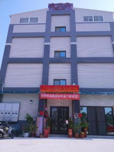 un edificio con una señal roja delante de él en 金門馨紫晶民宿, en Jinning