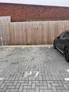 a car parked in a parking lot next to a fence at Cosy Suite in Shirley in Solihull