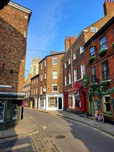 uma rua da cidade vazia com edifícios de tijolos e um edifício em 50a Low Petergate em York