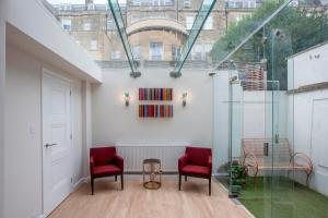 a room with two red chairs and a glass wall at ※ Spacious Georgian Coach House & with Parking (TCH) ※ in Bath