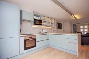 an open kitchen with white cabinets and a living room at ※ Spacious Georgian Coach House & with Parking (TCH) ※ in Bath