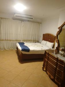 a bedroom with a bed and a dresser in it at Hoppa Guest House Nile View in Luxor