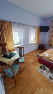 Habitación con cama, mesa y sillas. en Zajazd-restauracja Zyga en Iwkowa