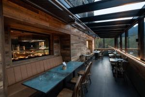 un restaurante con paredes de madera, mesas y sillas en Hotel AnyosPark Mountain & Wellness Resort, en Anyós