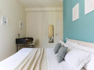 1 dormitorio con 1 cama blanca y paredes azules en The Best Rent - Morosini Apartment, en Milán