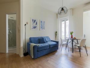 sala de estar con sofá azul y mesa en The Best Rent - Morosini Apartment, en Milán