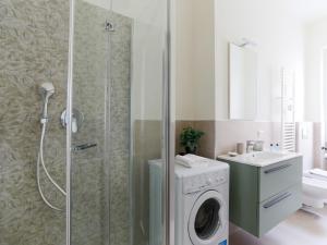 y baño con ducha y lavadora. en The Best Rent - Morosini Apartment, en Milán