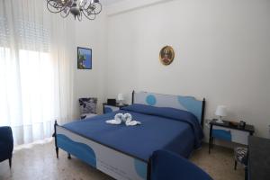 a bedroom with a blue bed with two towels on it at Dimora del Commendatore in Pozzallo