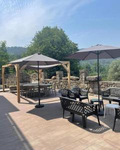 a patio with tables and chairs and umbrellas at Charming Villa with Pool and Jacuzzi - Terras de Bouro in Terras de Bouro