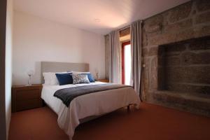 1 dormitorio con cama y pared de ladrillo en 7 bedrooms villa with private pool jacuzzi and furnished garden at Terras de Bouro, en Terras de Bouro
