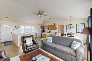 uma sala de estar com um sofá e uma cadeira em Bayshore Modern Beach House em Waldport