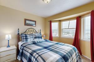 um quarto com uma cama e 2 janelas com cortinas vermelhas em Bayshore Modern Beach House em Waldport