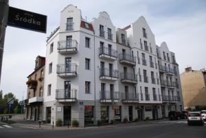 a white building on the corner of a street at Śródka Boutique Hotel in Poznań