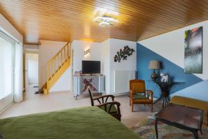een kamer met een bed, een televisie en een trap bij Maison avec piscine 20min plage in Guerlesquin