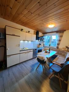 a kitchen with white cabinets and a table in a room at Haus Wallinger in Abtenau