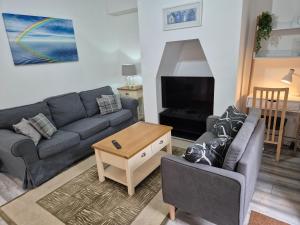 a living room with a couch and a tv at Cromwell Apartment by Cliftonvalley Apartments in Bristol