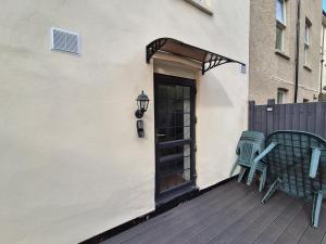 two chairs and a door on a deck at Cromwell Apartment by Cliftonvalley Apartments in Bristol