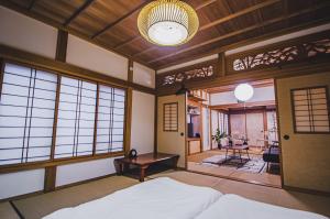 a room with a bed and a table and windows at 【佐渡/一棟貸切】オーシャンビュー古民家SeaSideStory椿 離れ in Sado
