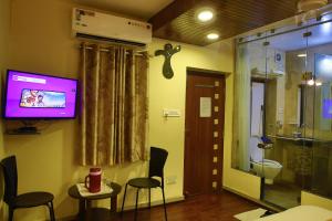 a room with a tv and a bathroom with a toilet at Shaleen Elegance Homestay Nakki Lake 400 meters in Mount Ābu