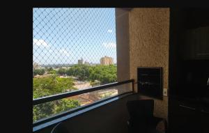 a balcony with a window with a view of a city at Quarto Bem no Centro Dourados in Dourados