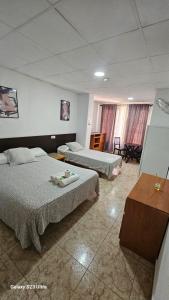 a hotel room with two beds and a table at Hostal Sol celeste in Lloret de Mar