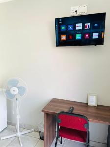 a desk with a fan and a tv on a wall at 473 On Cliff in Pretoria