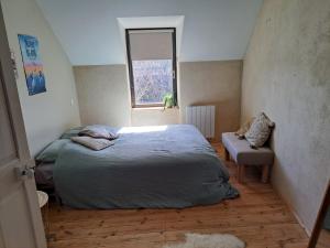 a bedroom with a bed and a chair and a window at 600m bord de mer centre du val andre la maison des prés in Pléneuf-Val-André