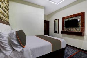 a bedroom with a bed and a flat screen tv at Collection O B SQUARE VILLA in Visakhapatnam