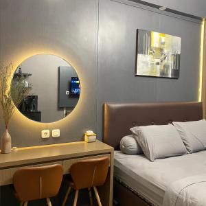 ein Hotelzimmer mit einem Bett und einem Spiegel in der Unterkunft Apartemen Bale Hinggil Studio in Medokansemampir