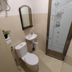 ein Bad mit einem WC, einem Waschbecken und einer Dusche in der Unterkunft Apartemen Bale Hinggil Studio in Medokansemampir