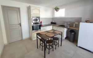 a small kitchen with a table and a refrigerator at LES JARDINS D'ORANGE in Orange