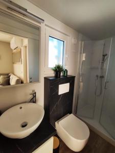 y baño con lavabo, ducha y aseo. en Mobile home Kala en Biograd na Moru