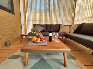 a living room with a table with a bottle of wine and fruit at Mobile home Kala in Biograd na Moru
