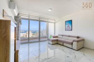 a living room with a couch and a large window at Designer home with stunning sea views in St Pauls by 360 Estates in St Paul's Bay