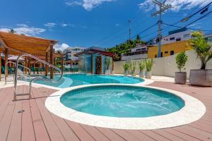 een groot zwembad op een patio met een gebouw bij Pousada Praia Bela in Ilhéus